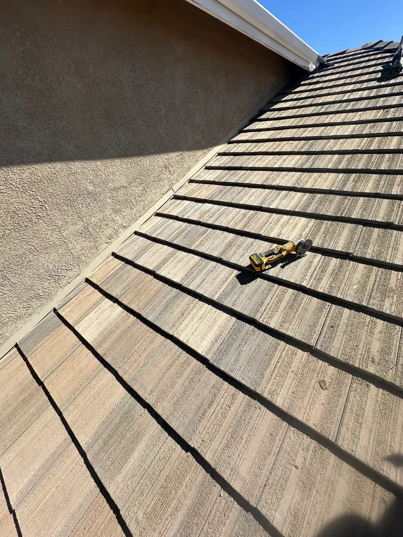 Tile roof surface with a tool resting on the tiles during repair work